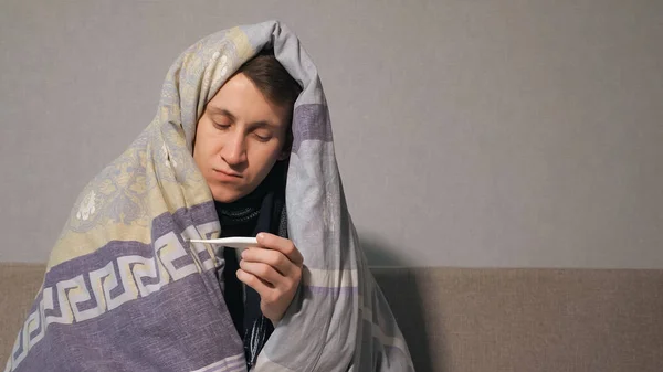 Hombre enfermo en manta tomando temperatura — Foto de Stock