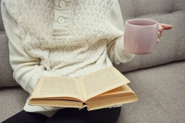 Неизвестная женщина с чашкой чая и книгой для чтения — стоковое фото
