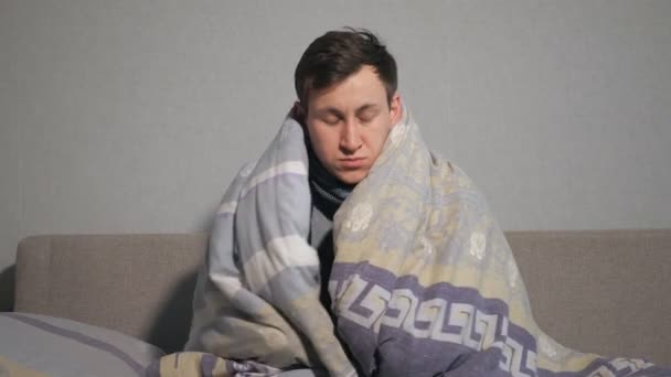 Unhappy young man wrapping in warm blanket — Stock Video