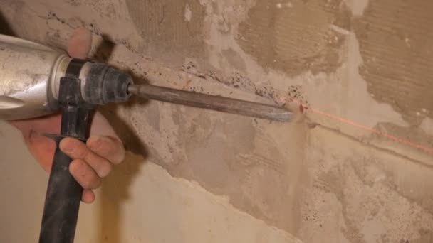 Рабочий снос стены с помощью инструмента — стоковое видео