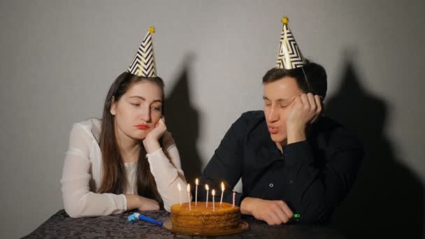 Грустная одинокая женщина и мужчина в шляпе празднуют день рождения в одиночестве — стоковое видео