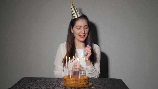 Одинокая женщина празднует праздник, он сидит один за столом с тортом и свечами — стоковое видео