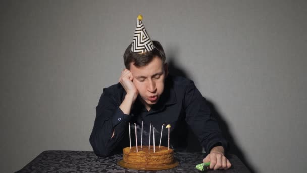 Droevige, eenzame man in feest hoed viert verjaardag alleen — Stockvideo