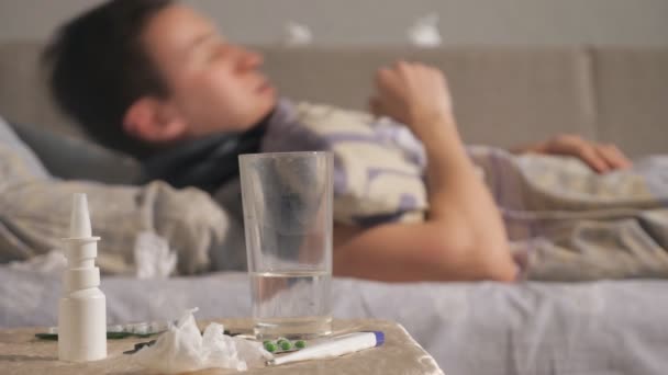 Лекарство и стакан воды рядом с больным парнем — стоковое видео