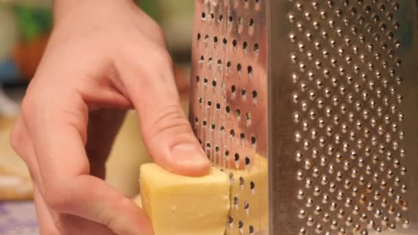 Queijo de mussarela que passa pelo ralador tiro de um pedaço de queijo — Vídeo de Stock