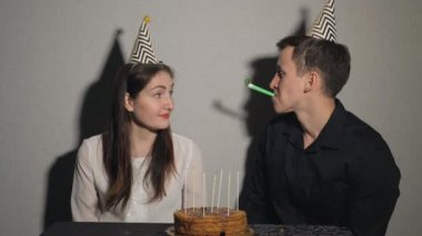 Çift gülümseyen parti üfleyiciler ile oynarken bir tatil kutluyor