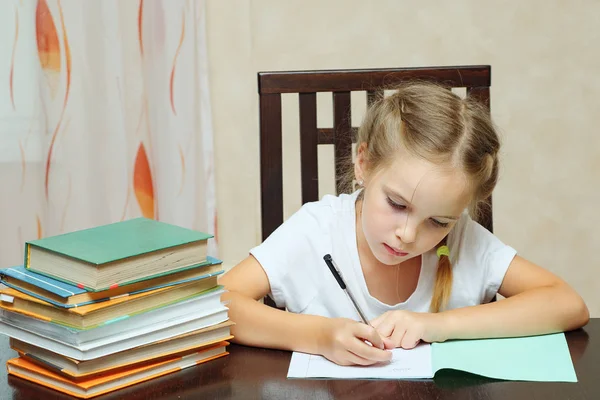 Menina concentrada fazendo lição de casa da escola — Fotografia de Stock