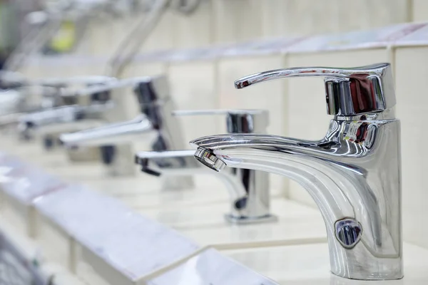 Water taps standing on shelf in shop — Stock Photo, Image