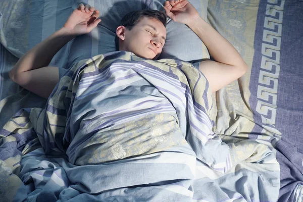 Un hombre se despierta de la pesadilla, el mal sueño y el sueño inquieto por la noche — Foto de Stock