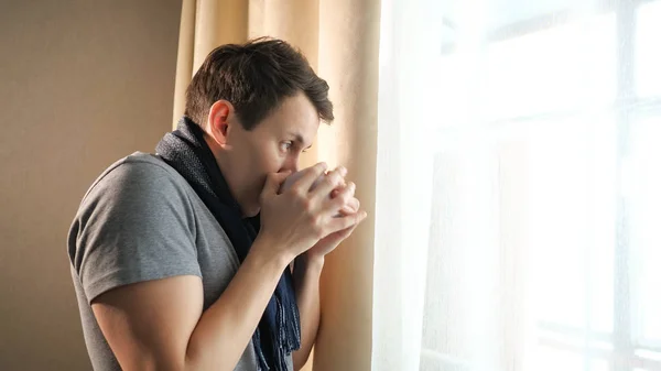 Хворий чоловік з куховарським кашлем біля вікна — стокове фото