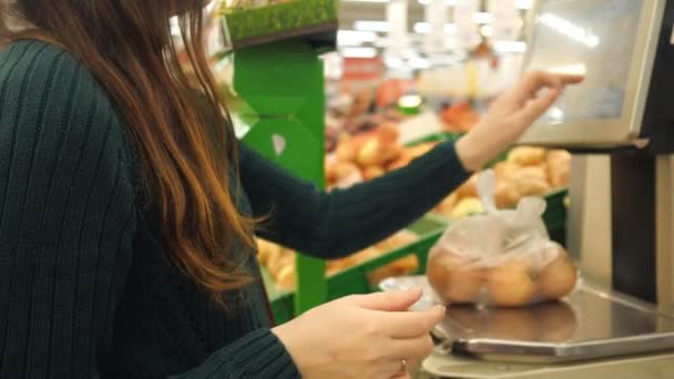 Felismerhetetlen nő súlya burgonya műanyag zacskóba skálán, élelmiszerbolt — Stock videók