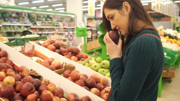 Ung kvinna att välja rött äpple på frukt grönsaker stormarknad marknadsplats — Stockvideo