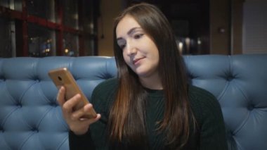 kafede oturan ve smarphone kullanarak kazaklı kız