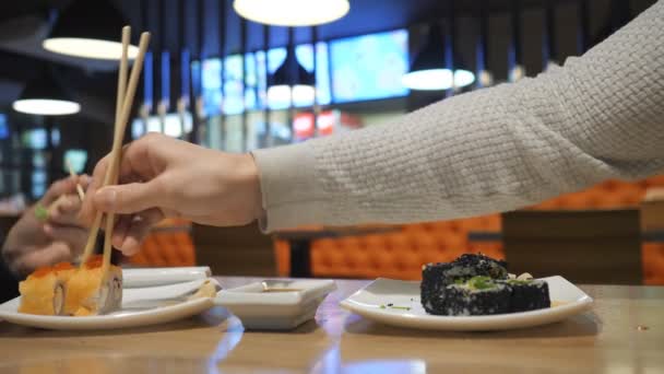 Pareja feliz comiendo rollos de sushi en el restaurante japonés, bar de sushi . — Vídeos de Stock