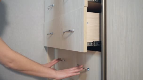 Menina fecha as gavetas no armário — Vídeo de Stock