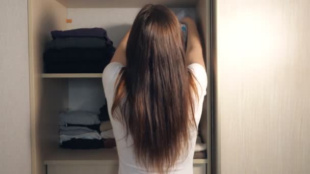 Женщина убирает в шкафу. . — стоковое видео