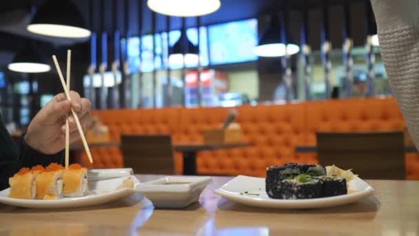Šťastný pár jíst sushi rolls v Japonsku restaurace, sushi bar. — Stock video