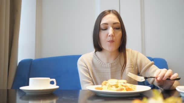 Mujer comiendo ensalada sentada en la cafetería — Vídeo de stock