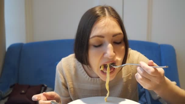 Закрыть глаза на голодную женщину, которая ест пасту в кафе . — стоковое видео