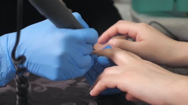 A manicure faz o procedimento de manicure de recuperação e extensões de unhas nas unhas da menina no salão de beleza — Vídeo de Stock