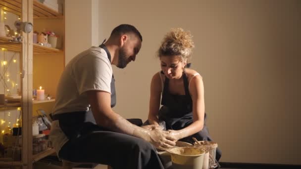 Man en een vrouw maken van klei kruik op potters wiel. — Stockvideo