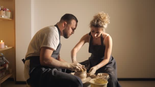 Romantic couple in love working together on potter wheel and sculpting clay pot, — Stock Video