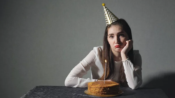 Triste mujer solitaria en sombrero de fiesta celebrando cumpleaños sola —  Fotos de Stock