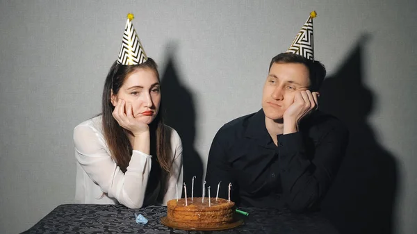 Triste donna solitaria e uomo in cappello da festa che festeggia il compleanno da solo — Foto Stock
