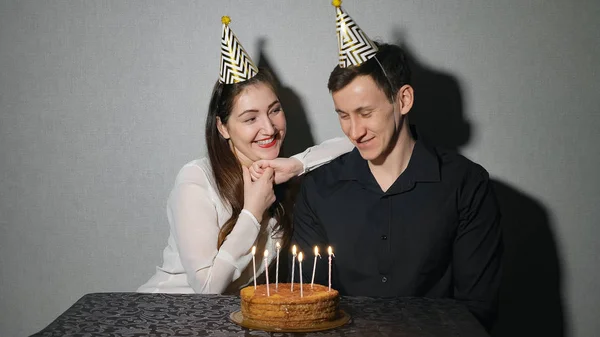 Jovem mulher e homem celebra um feriado com um bolo e velas — Fotografia de Stock