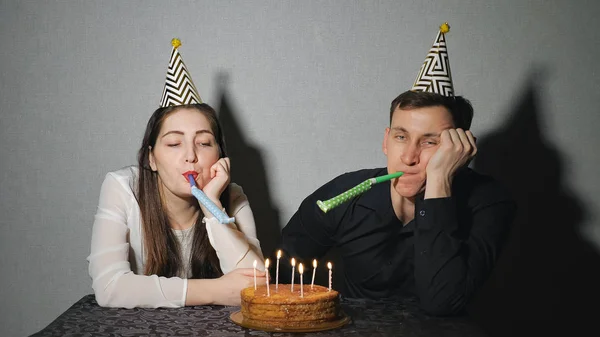 Triste mujer solitaria y hombre en sombrero de fiesta celebrando cumpleaños solo —  Fotos de Stock