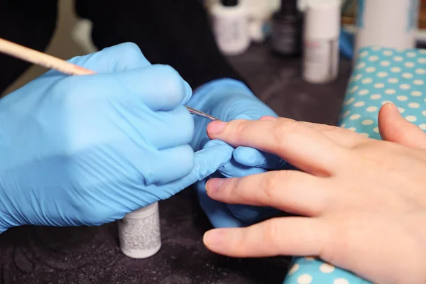 Woman hands in a nail salon receiving a manicure by a beautician — Stock Photo, Image