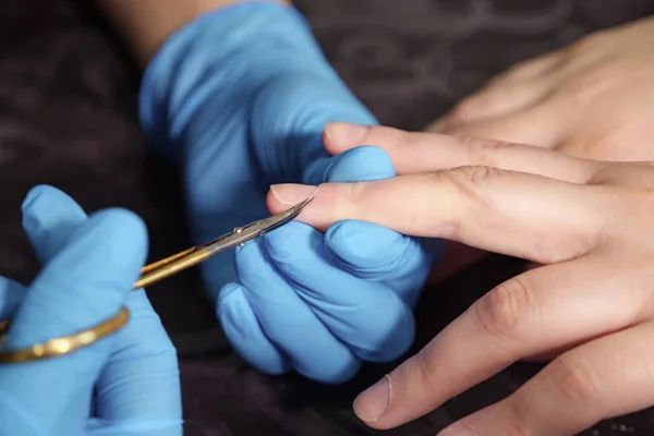 Female hands in nail salon receiving a manicure by a beautician. — Stock Photo, Image