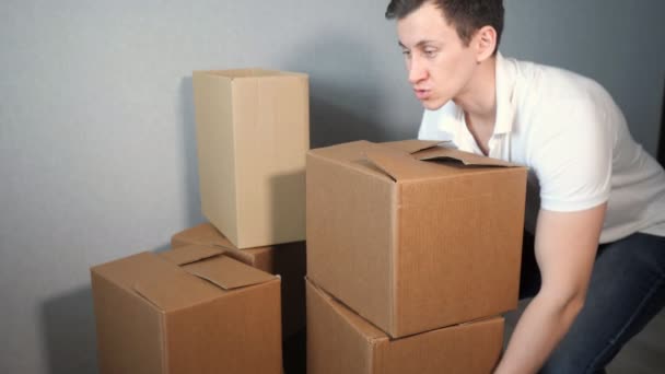 Mladí doručovatel službu vyžaduje spoustu lepenkové krabice a těžkých krabic pádu — Stock video