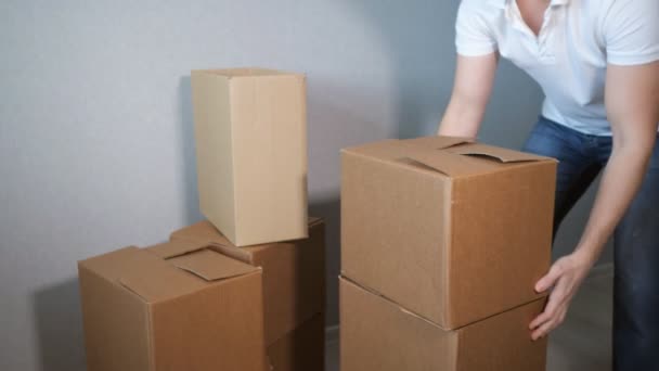 Inexperienced young delivery service man takes a lot of cardboard box and boxes falling — Stock Video