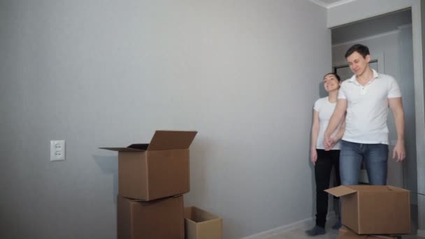 Молода пара дуже щаслива і схвильована тим, що переїхала в нову квартиру — стокове відео