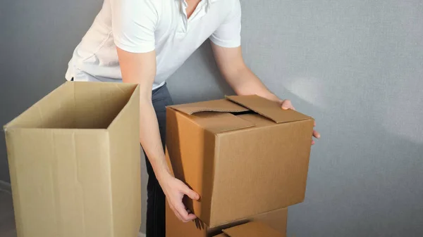 Молодой доставщик с коробками в новый дом в день переезда — стоковое фото