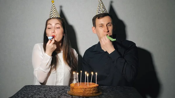 党ブロワと遊ぶ休日を祝うカップルの笑顔 — ストック写真