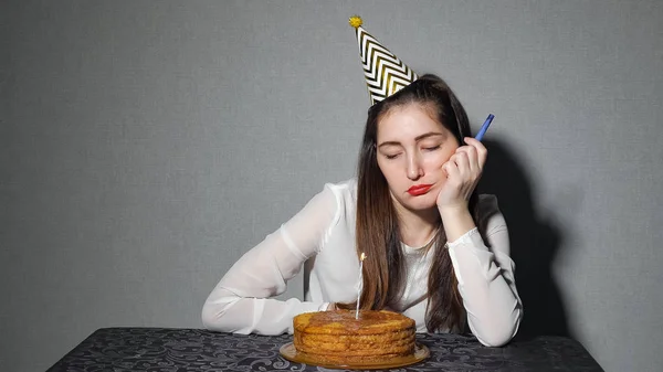 Triste mulher solitária em chapéu de festa celebrando aniversário sozinho — Fotografia de Stock