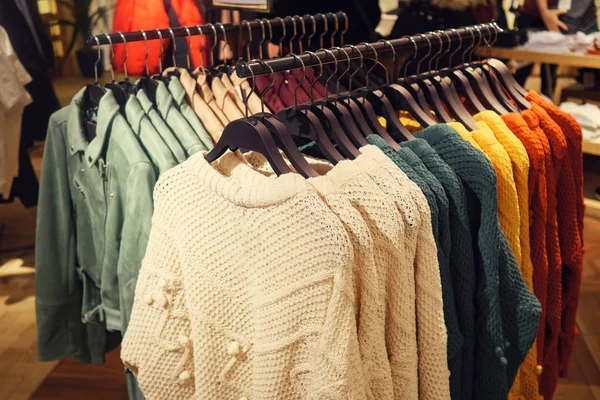 Stylish multicolored sweaters on rack — Stock Photo, Image