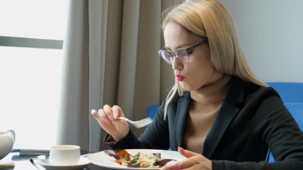 Mujer comiendo ensalada sentada en la cafetería — Vídeos de Stock