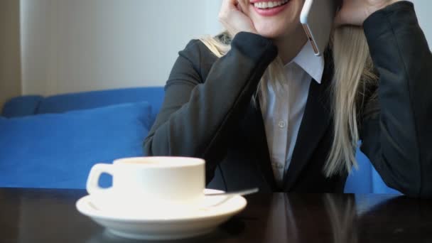 无法辨认的微笑的年轻女子有友好的电话交谈, 而在咖啡馆喝咖啡. — 图库视频影像