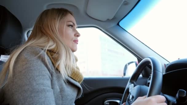 Junges blondes Mädchen, das tagsüber Auto fährt — Stockvideo