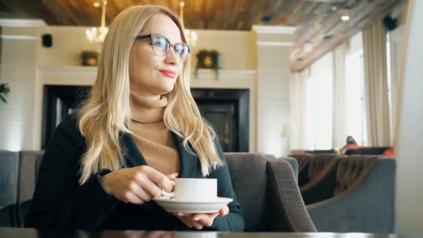 Šťastná dívka pití kávy a relaxaci v kavárně — Stock video