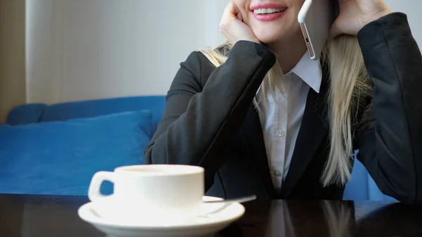 인식할 수 없는 웃는 젊은 여자 카페에서 커피를 마시는 동안 친절 한 전화 대화. — 스톡 사진