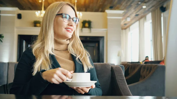 Glad tjej dricka kaffe och koppla av i caféet — Stockfoto