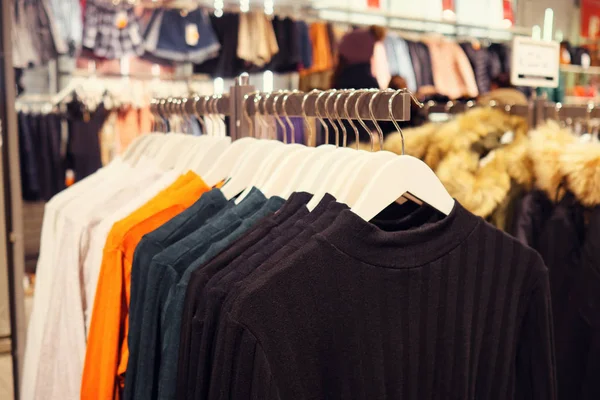 Stylish multicolored sweaters on rack — Stock Photo, Image