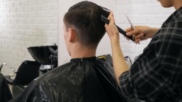 女手理发师剃须男子与电动剃须刀在理发店 — 图库视频影像