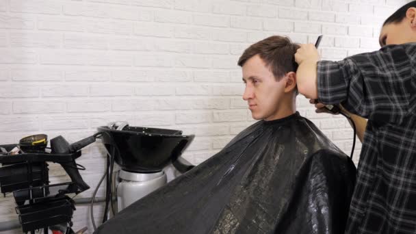 Hombre consiguiendo un corte de pelo por un peluquero. — Vídeos de Stock