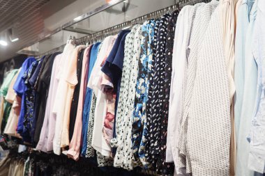 Modern giysiler dükkanda metal raf asılı zarif ışık bluzlar