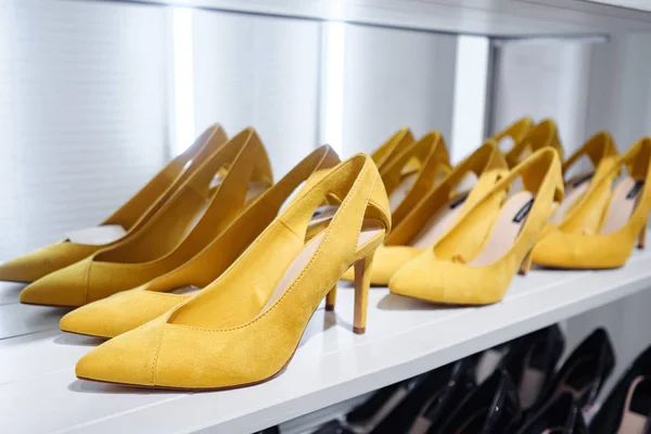 Trendy bright-colored shoes on shelf in shop